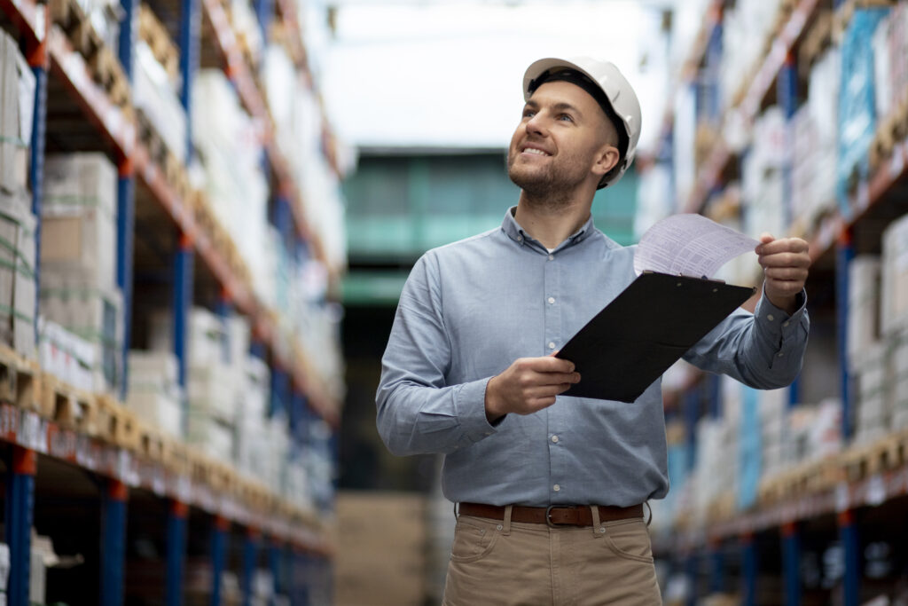 medium-shot-smiley-man-warehouse. Top 5 Freight Forwarding Mistakes to Avoid in the UAE
